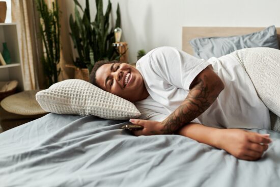 A,Cheerful,African,American,Woman,Awakens,In,Her,Stylish,Bedroom,